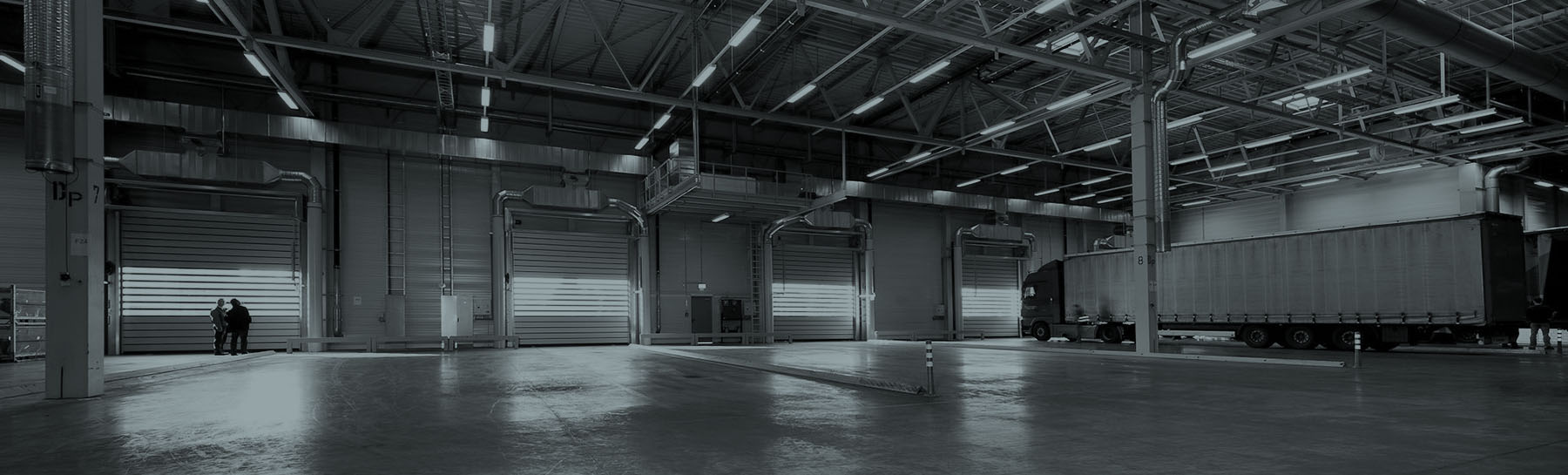 The interior of an industrial space where a freight car is parked - black and white image